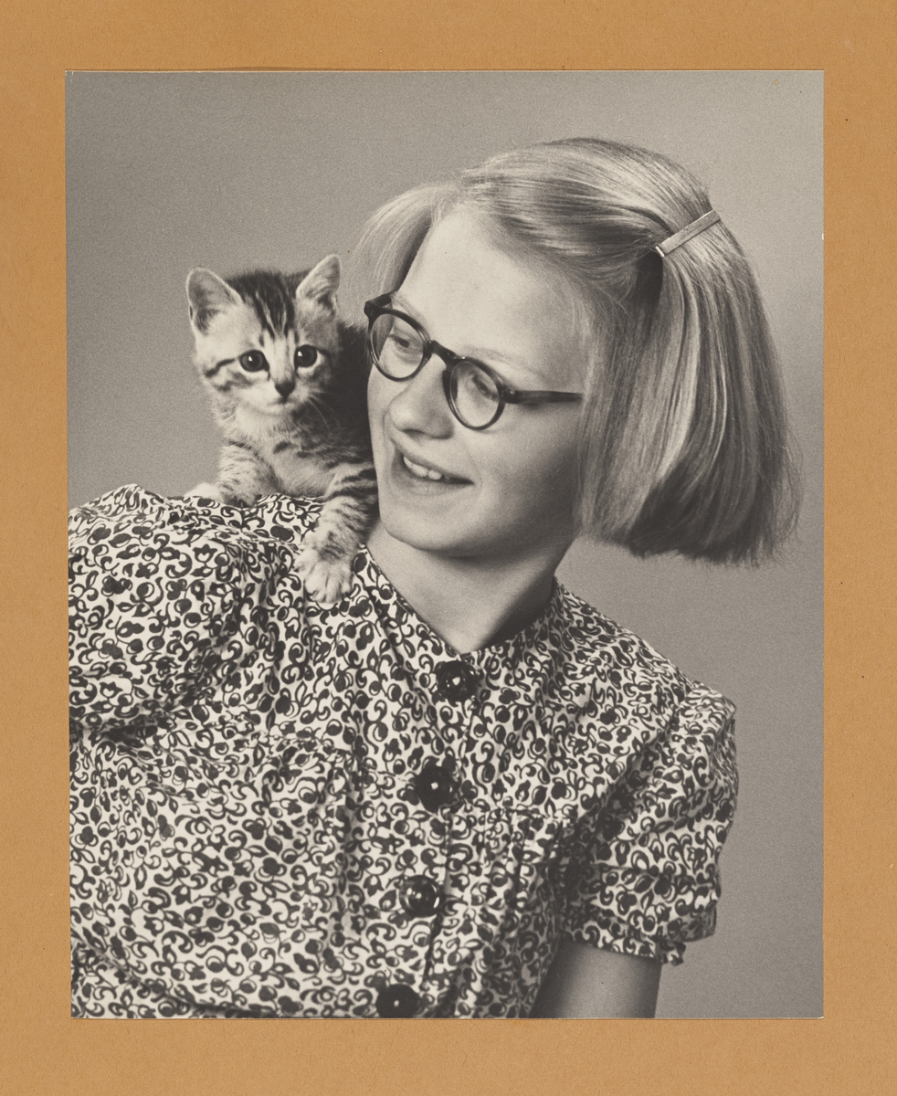 Jente med katt på skulderen