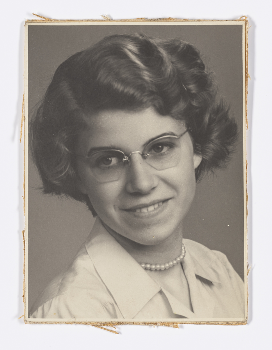 Ung kvinne med briller og perlekjede