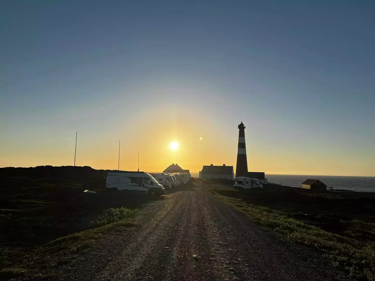 Slettnes fyr i solnedgang, mange campingvogner.