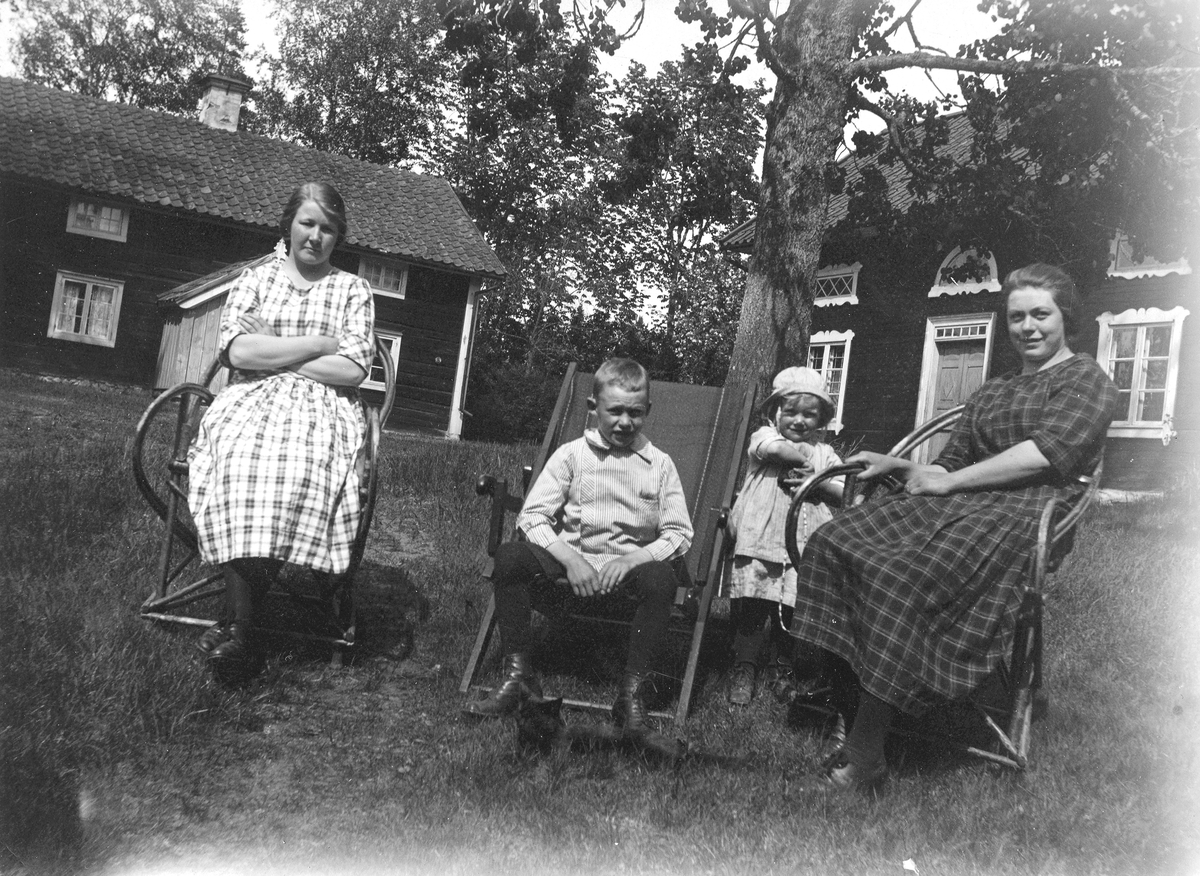 Fyra personer. 
Boningshuset och handelsboden i bakgrunden. 
Till höger på bilden Karin Almqvist, dotter till Alexander Gregorius Almqvist. 
Gunnar, givaren känner inte till de andra personerna. 
Pingst 1922.