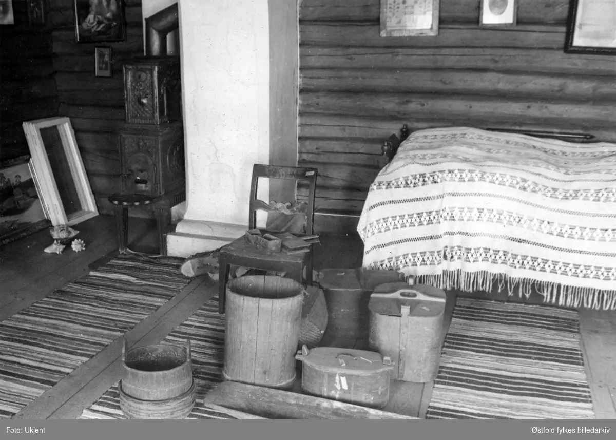 Gården Alvim nordre i Tune, fotografert februar 1977.
Fra våningshus, soveromsinteriør - ant fra kammers eller loftsrom. Seng (uttrekksseng?) med teppe, tiner, stol, karde, bilder, lampe, filleryer - vevde.
Våningshus bygd omrking 1780, restaurert 1955.