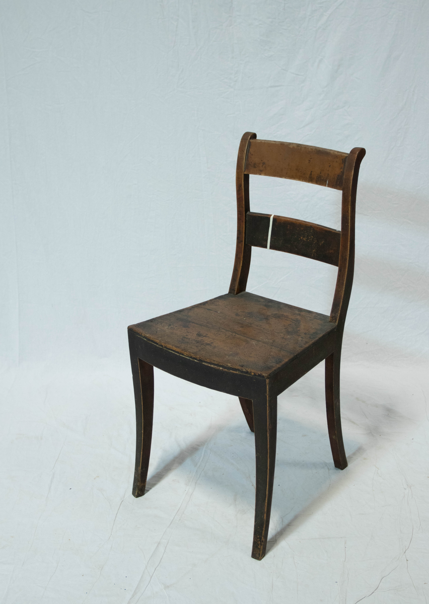 Stol av tre. Stolen har fire sabelformede og krummede ben, glatte sidesprosses. Ryggstavene til stolen er  S-svungne og forbundet med to glatte og horisontale bretter. Setets fremkant er horisontalt buet.