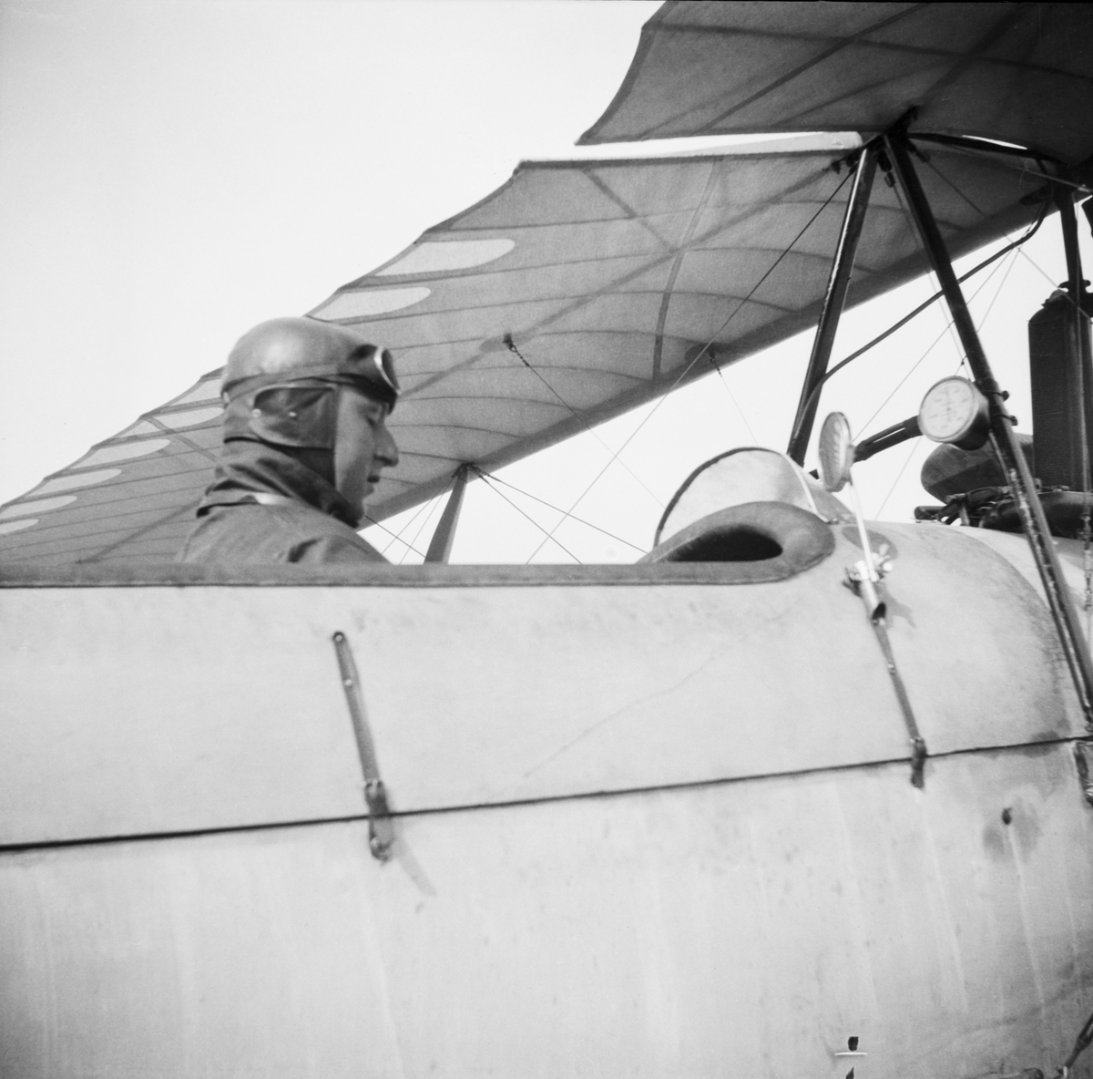 Edmund Sparmann i förarsits på miliärt flygplan tillhörande Österrike-Ungern under första världskriget. Vy snett bakifrån, närbild