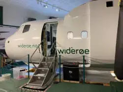 Widerøes Dash 8 kabinsimulator med åpen passasjerdør. Gulvet