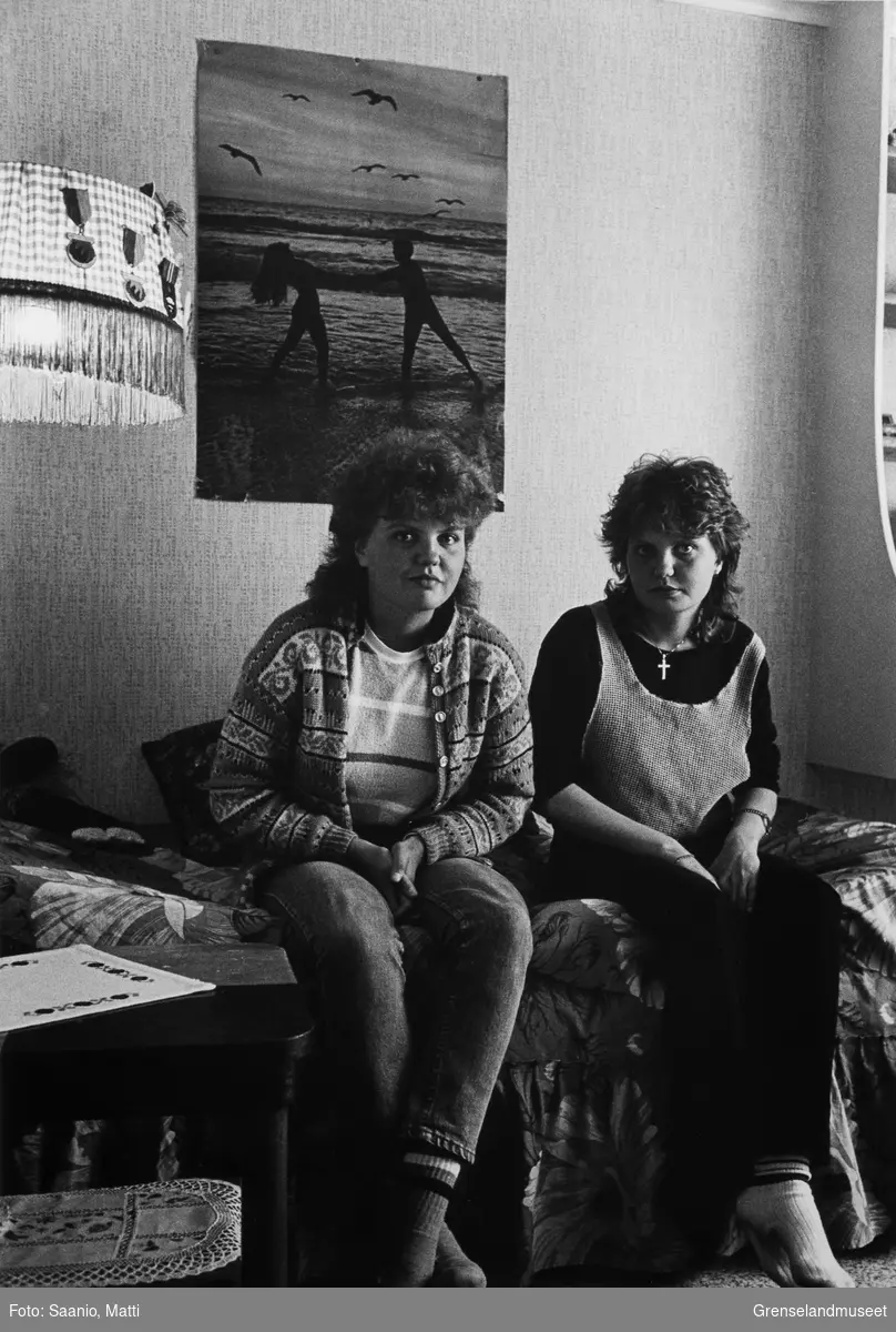 Tvillingene Bodil og Bente Abrahamsen sitter på senga på jenterommet. På veggen henger en plakat med strandmotiv. Bugøynes på 80-tallet.