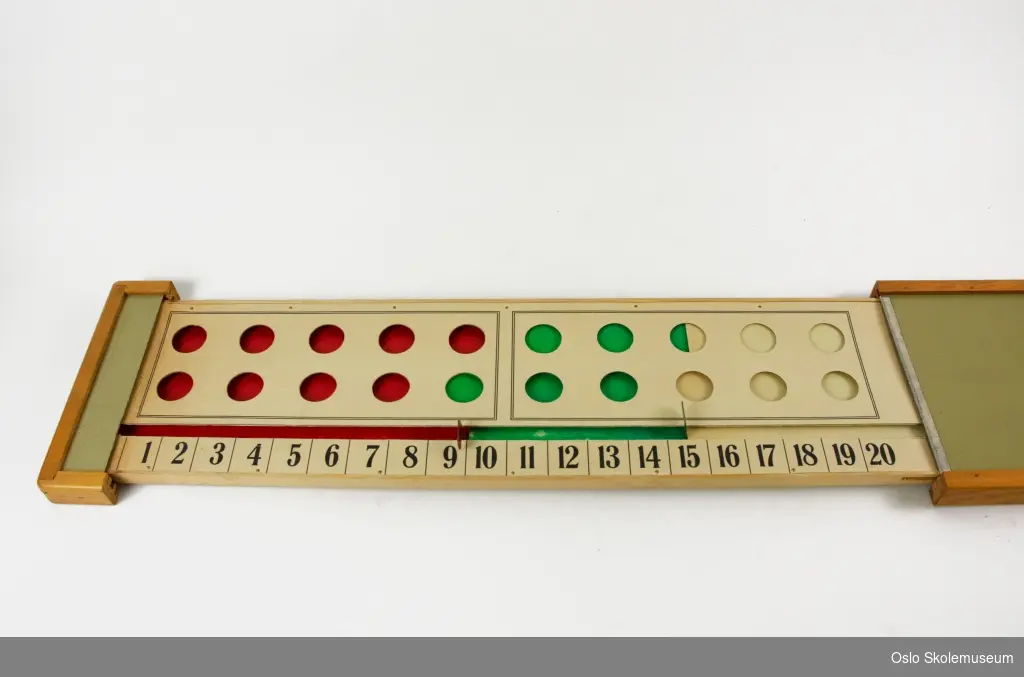 Rektangulært undervisningsverktøy for matematikk. Den ene siden kan dras ut for å vise en plate med tallene 1 til 20 med 20 hull over. Ved å dra to metallspaker frem og tilbake kan man bestemme om hullene skal være røde, grønne eller beige.