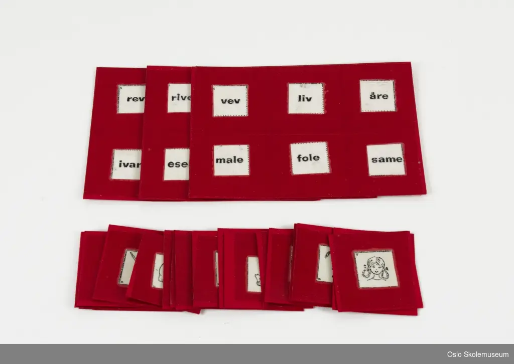 Lese-/norskspill som består av tre røde spillbrett samt kvadratiske kort i papp. Hvert spillbrett har seks ord. Kortene har illustrasjoner i svart/hvitt.