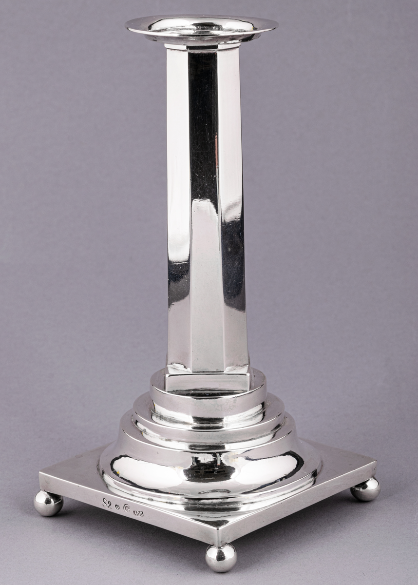 En av ett par gustavianska ljusstakar i silver stämplade Anders Dunderberg, Gävle 1800. Stram åttaformat ben med avtagbar manschett, rektangulär terrasserad fot med kulfötter. Mästarstämpel på fotens sida: S2 tre kronor G A.DB.