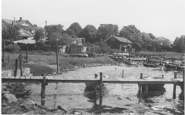 Småbåtshamnen i innerviken i Gottskär. Bryggor med förtöjda småbåtar och bostadsbebyggelse.