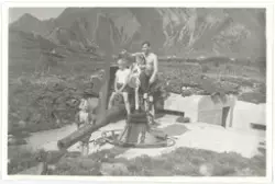 Mann med tre unger på en kanonstilling med bunker.