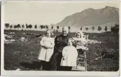 Bestemor med tre barnebarn, et av dem på barnestol