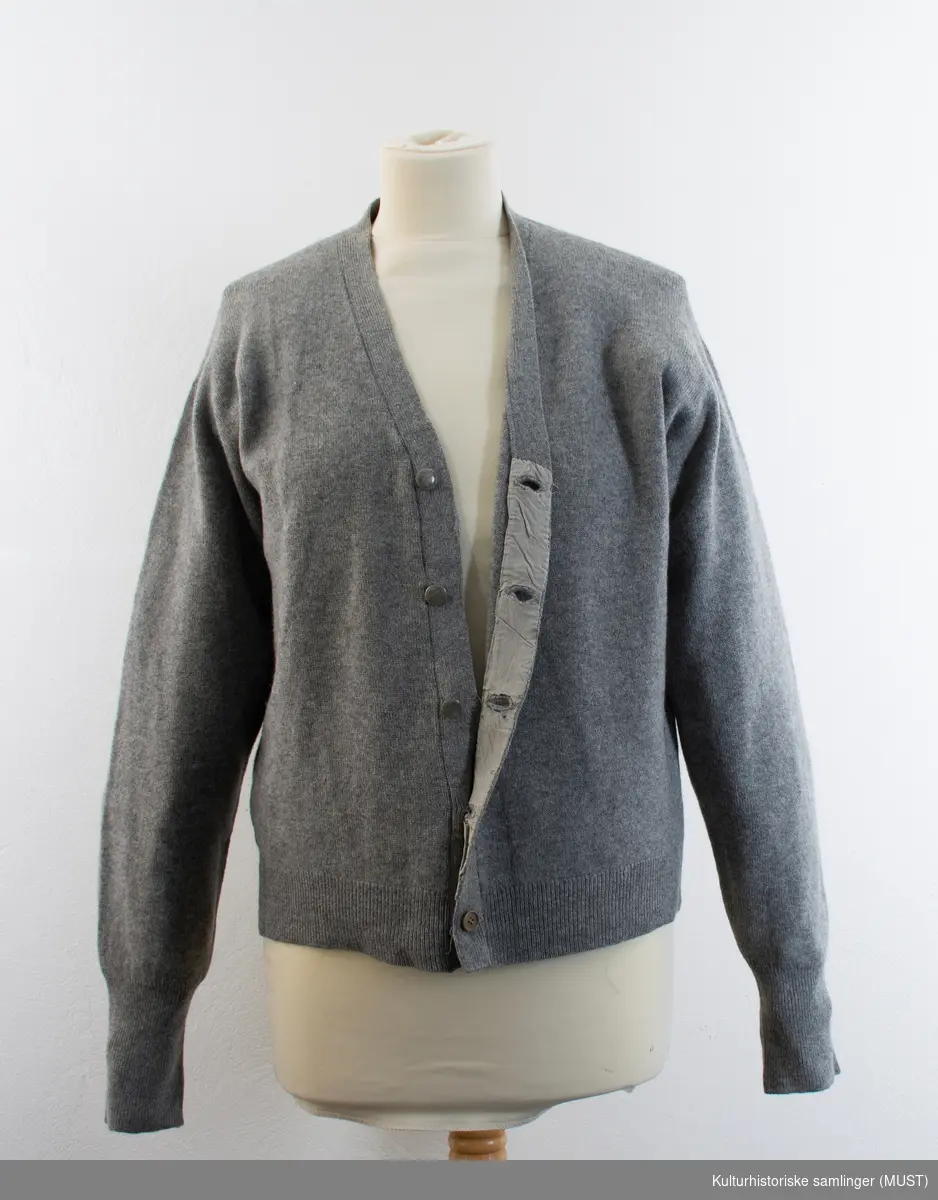 Strikkejakke i grå tynn ull, med V-hals og knappestolpe med fem gråknapper.
