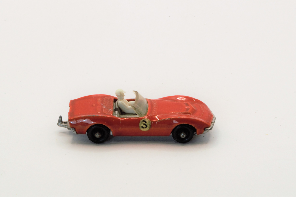 Rød lekebil fra 60/70-tallet. Produsert i England. Corvette, rød sportsbil med sjåførfigur.