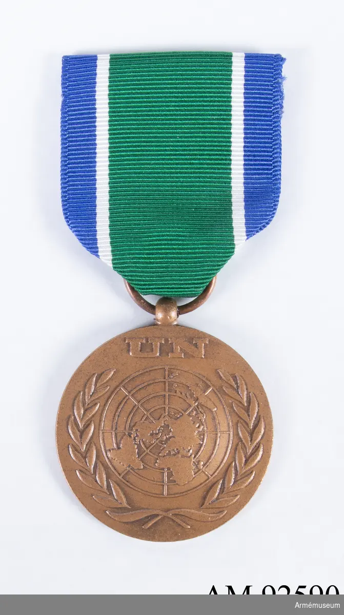 FN-medalj i brons med grönt band med vit och blå rand i kanten. En enkel säkerhetsnål är löst fastsydd på baksidan av bandet.
Band i blått och vitt användes när insatsen i Kongo inledds 1960. 1962 byttes banden till färgerna blå-vit-grön som på detta exemplar.
Medaljen pryds av FN-symbolen och "UN" på framsidan, på baksidan står texten "In the Service of Peace".