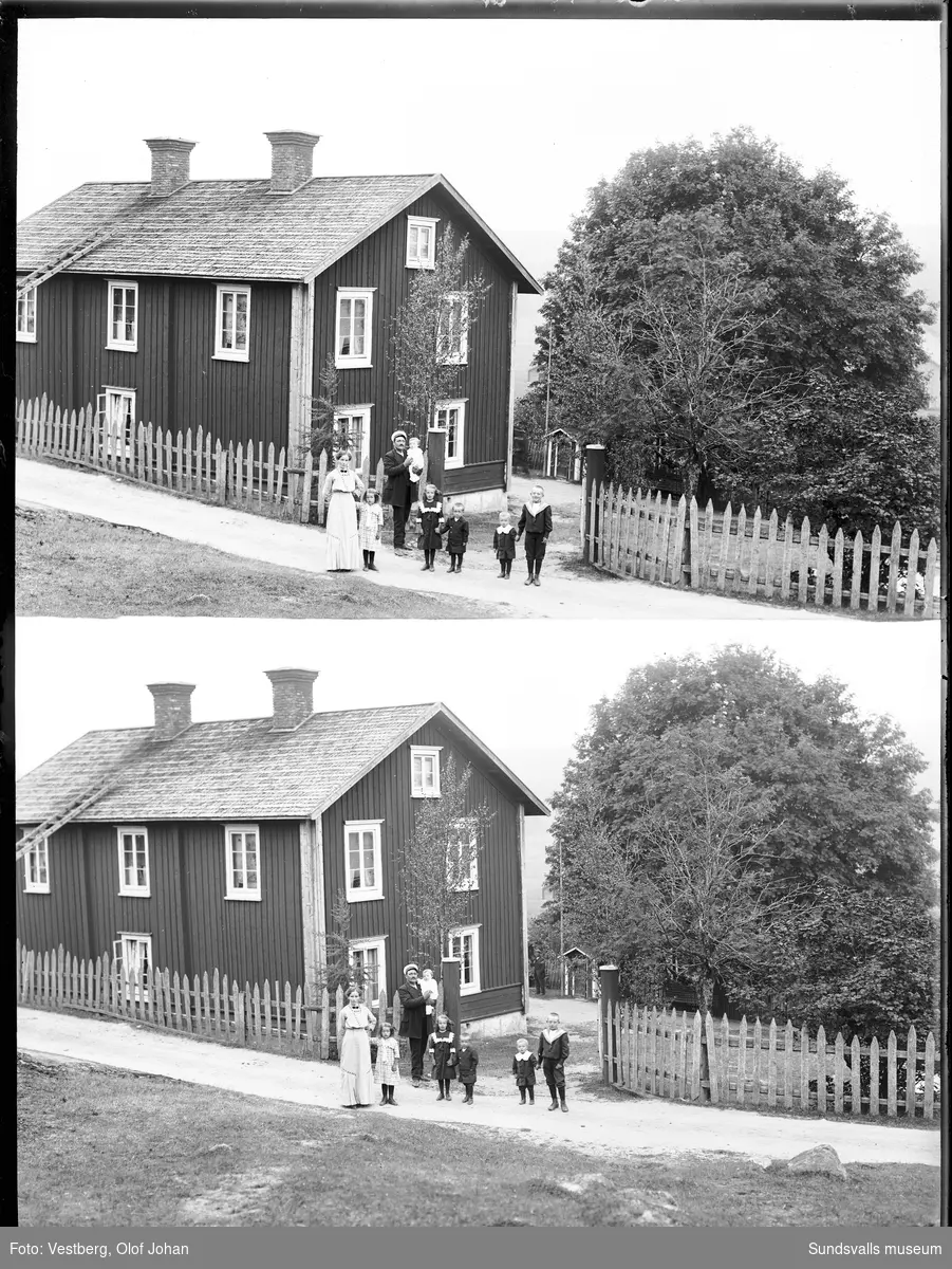 En dubbel vy mot ett tvåvånings bostadshus i Berga, Mjösund. På landsvägen vid staketet står husets familj - mor, far och sex barn. Se även SuM-foto035159.