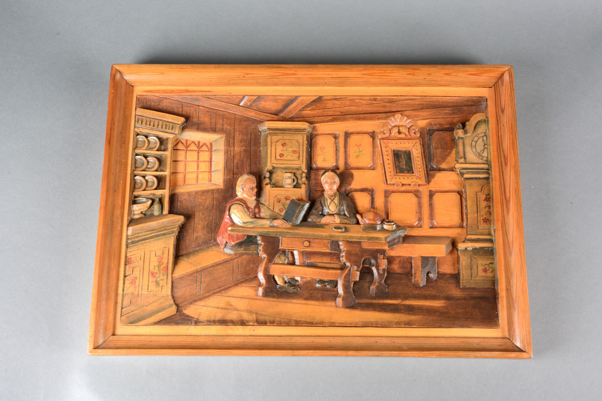 Eldre ektepar sittende i en møblert bondestue. Paret er kledd i søndagsklær. Mannen leser fra en bok (huspostill), mens konen lytter.