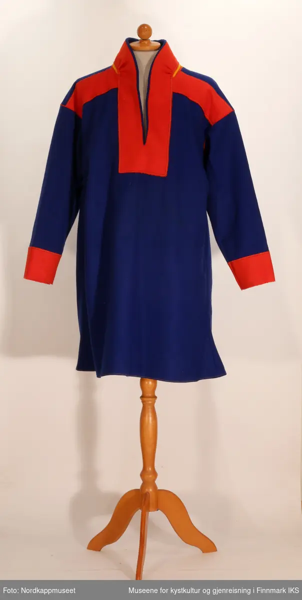En samisk herrekofte (gàkti) sydd av blått ullstoff. 

På skuldrene og kragen er det sydd brede border av rødt og gult ullstoff. Rundt halsåpningen og på ryggen er det sydd border av rødt ullstoff.