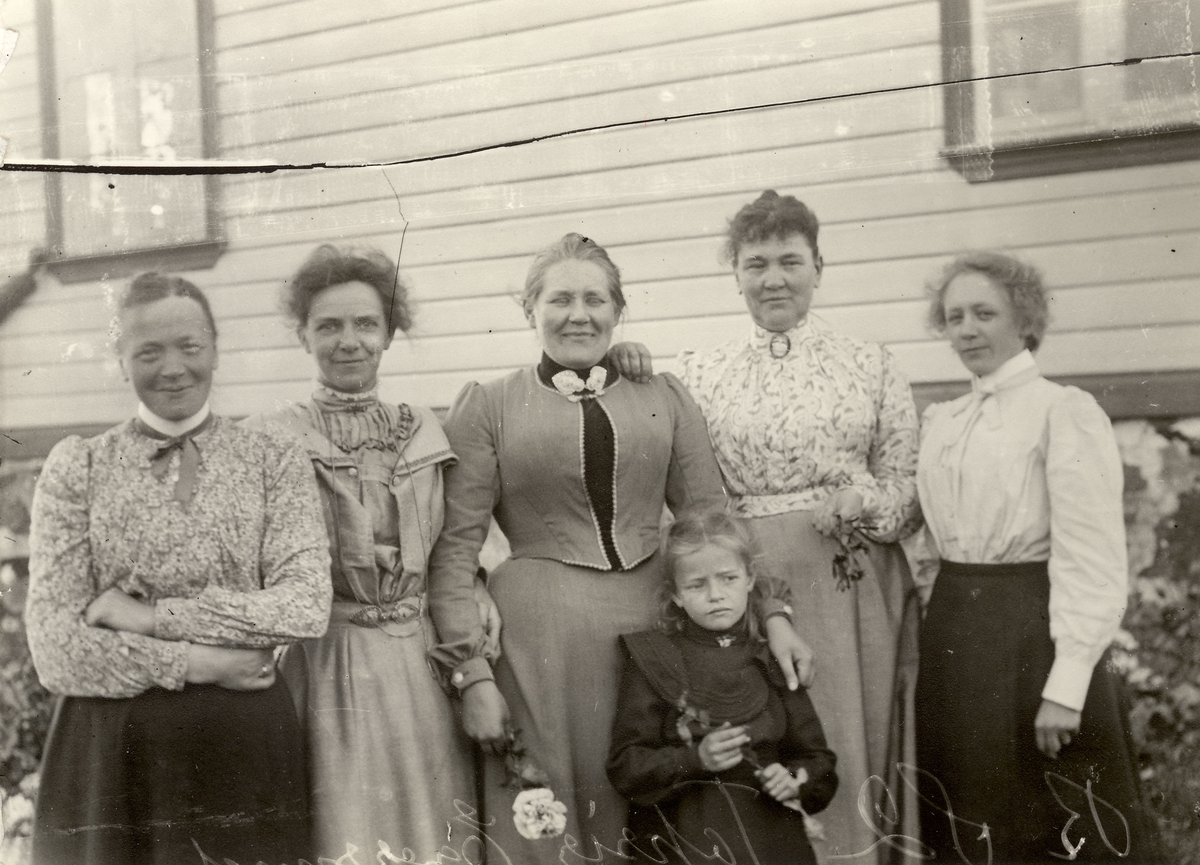 Fem ukjente damer og en jente, utenfor et hus et sted i Egersund