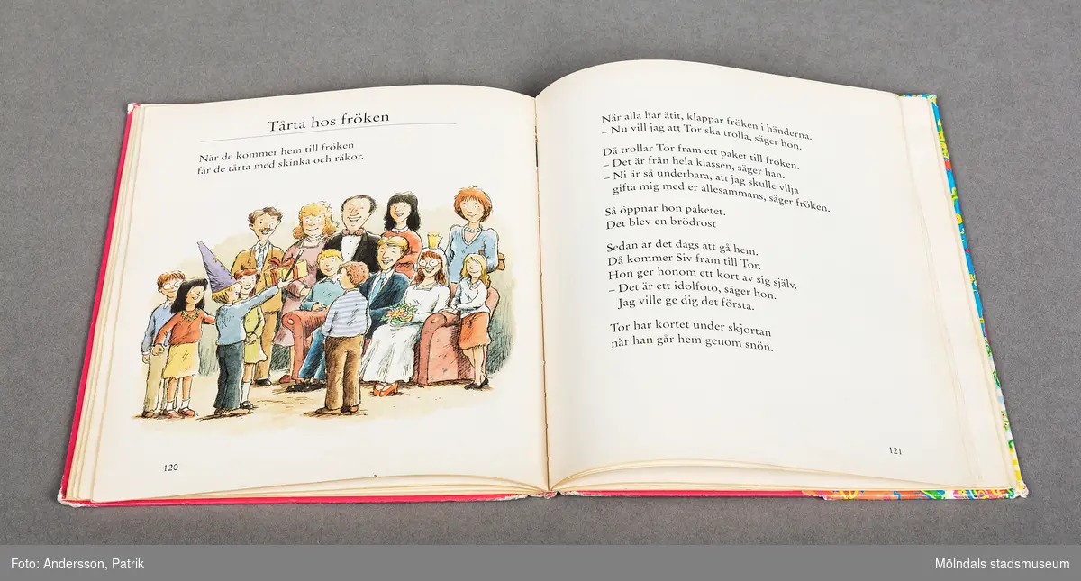 Bok: Vi läser. Andra boken. På framsidan finns en teckning av en äldre kvinna, två barn och en hund. De seglar med en flotte. Omslaget har rosa bakgrund med vita bokstäver. 

Boken innehåller enklare texter av flera olika författare och illustratörer.