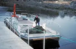 Simo 1988 : Flytebrygge med båt lagt til, en mann på dekk