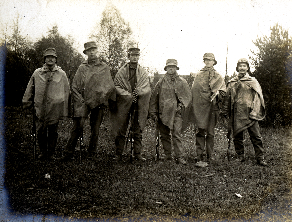 Soldater i regnværsantrek 1905.
Bilde er fra fotoalbum GM.036887.