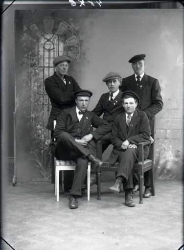 Ateljébild Fem unga män i olika slags kepsar fotograferade i Björkströms Falkenbergsfilial. Beställare: F Hjalmarsson, Morups Fyr.