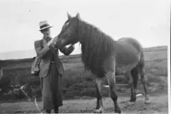 Portrett av Herman Liahagen med hest,hatt,jakke og nikkers