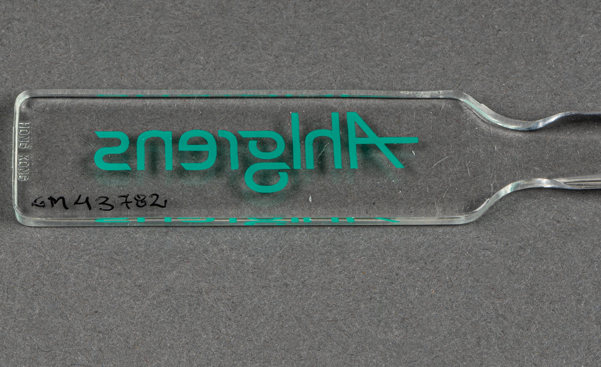 Brevkniv i plast, genomskinlig med grön text: Ahlgrens.