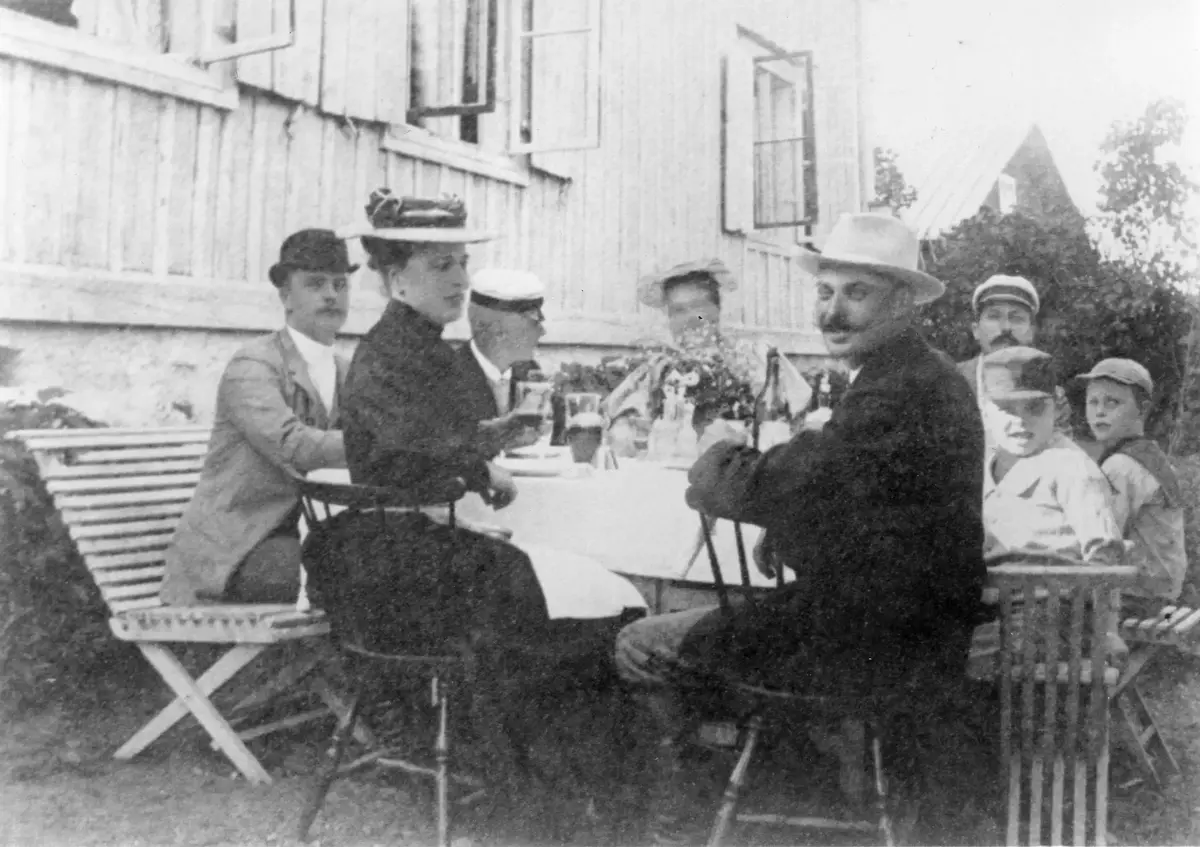 Familjen Salomonsson med gäster på en kaffestund i trädgården utanför Fågelbros norra flygel