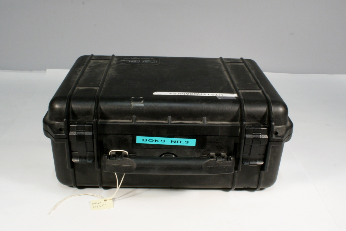 Rektangulær sort plastkoffert med foto- og videokamera, med blitz og strømforsyning.