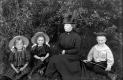 Fotografens kone og barn under bladkronene, ca 1912-1914.
Fr