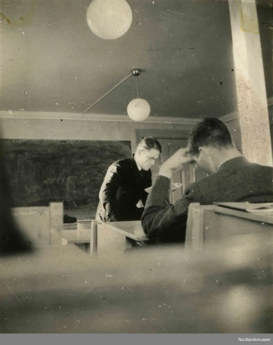 Inne i et klasserom. Bildetekst: "Weisent 1943".