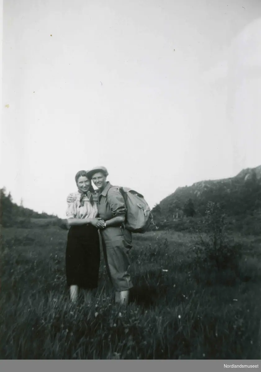 En ung kvinne og en ung mann fotografert utendørs. De holder rundt hverandre. Mannen har sekk på ryggen. Kvinnen har på seg skaut.