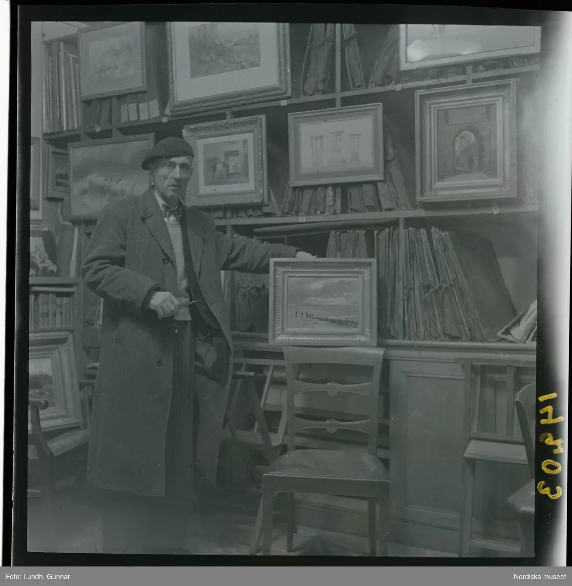 1950. Paris. En man stå inne i en butik med konst.