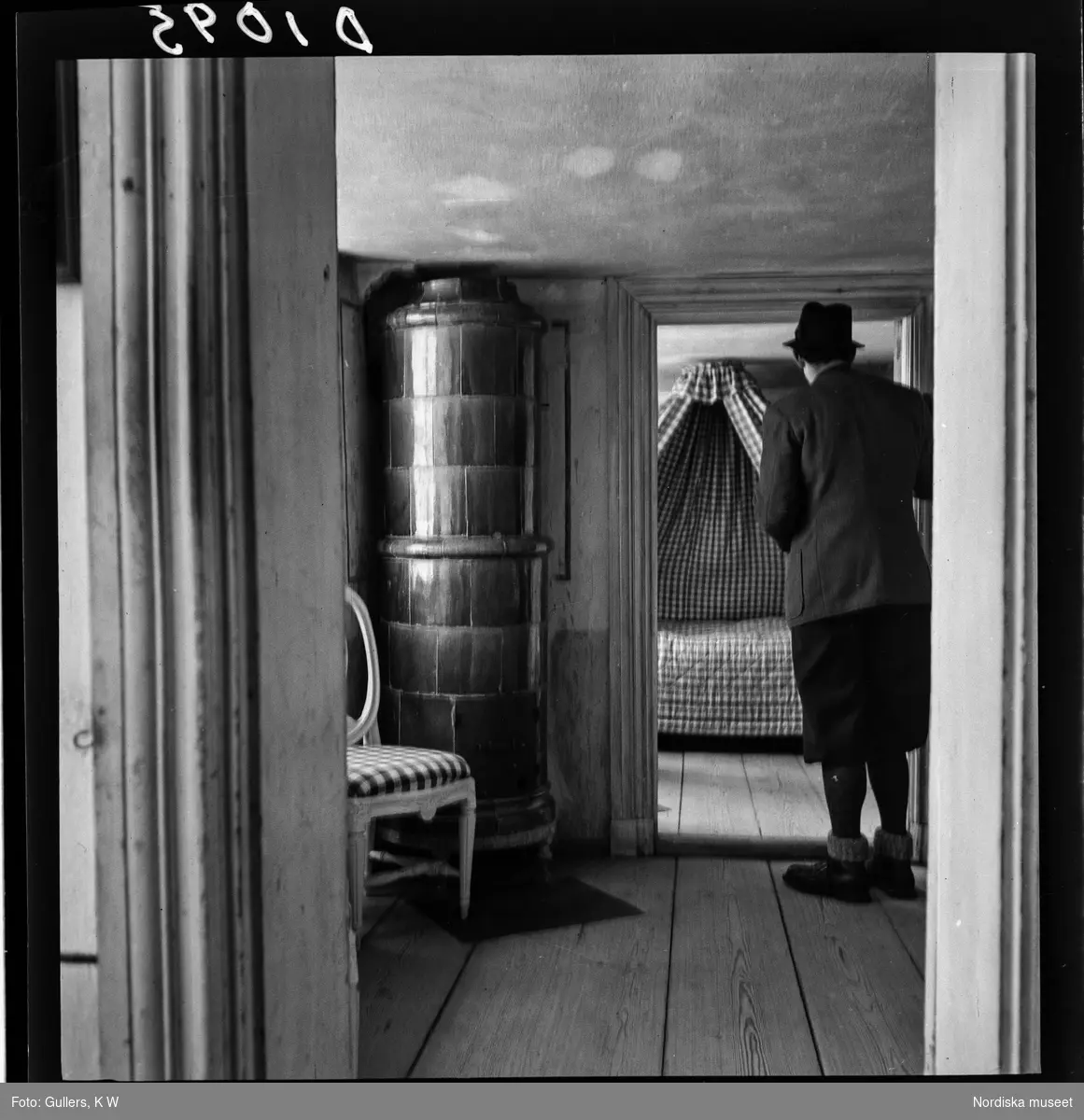 511 Gripsholms Slott för Allers. En man står i dörröppningen och tittar in mot ett sovrum.