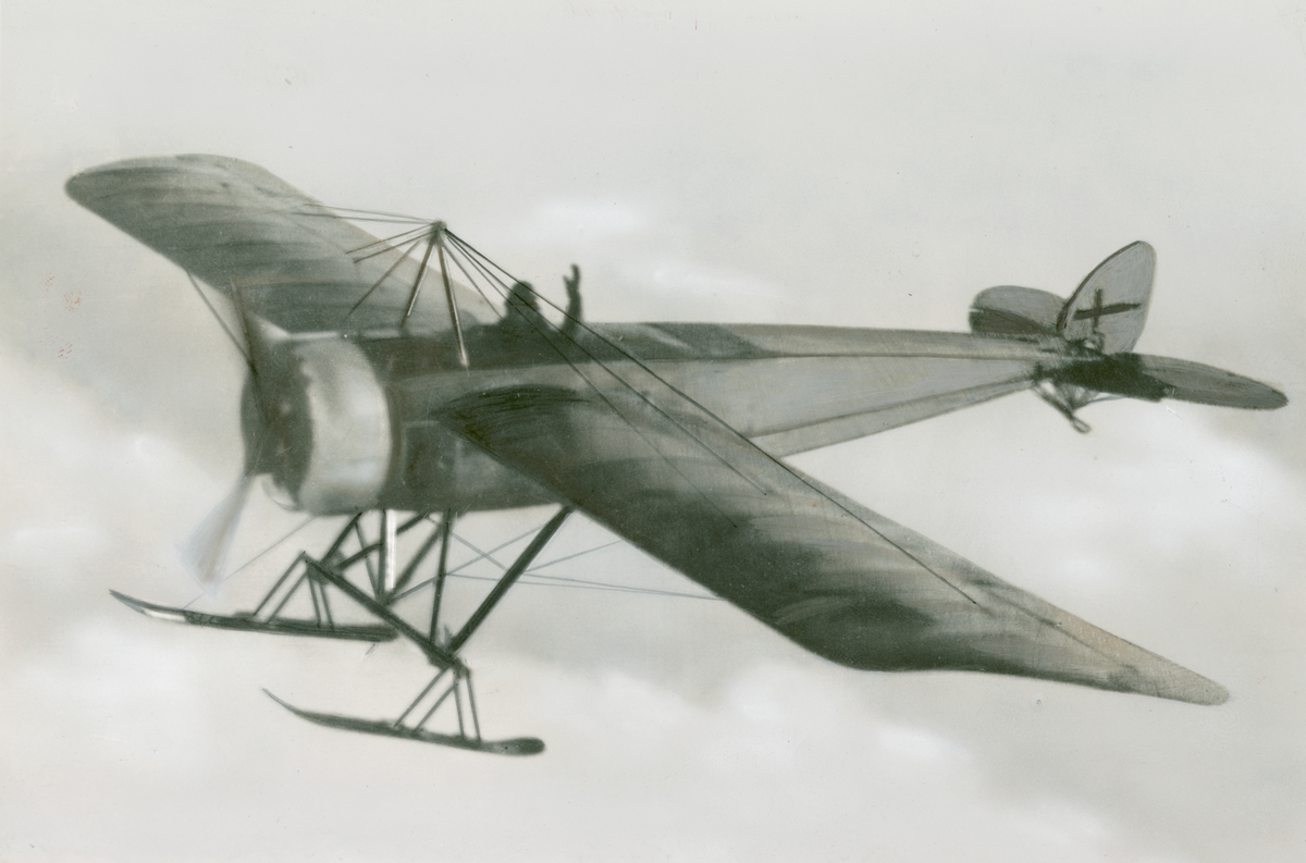 Flygbild av flygplan Thulin K i luften med Nils Rodéhn som flygförare, 1917. Moln i bakgrunden.