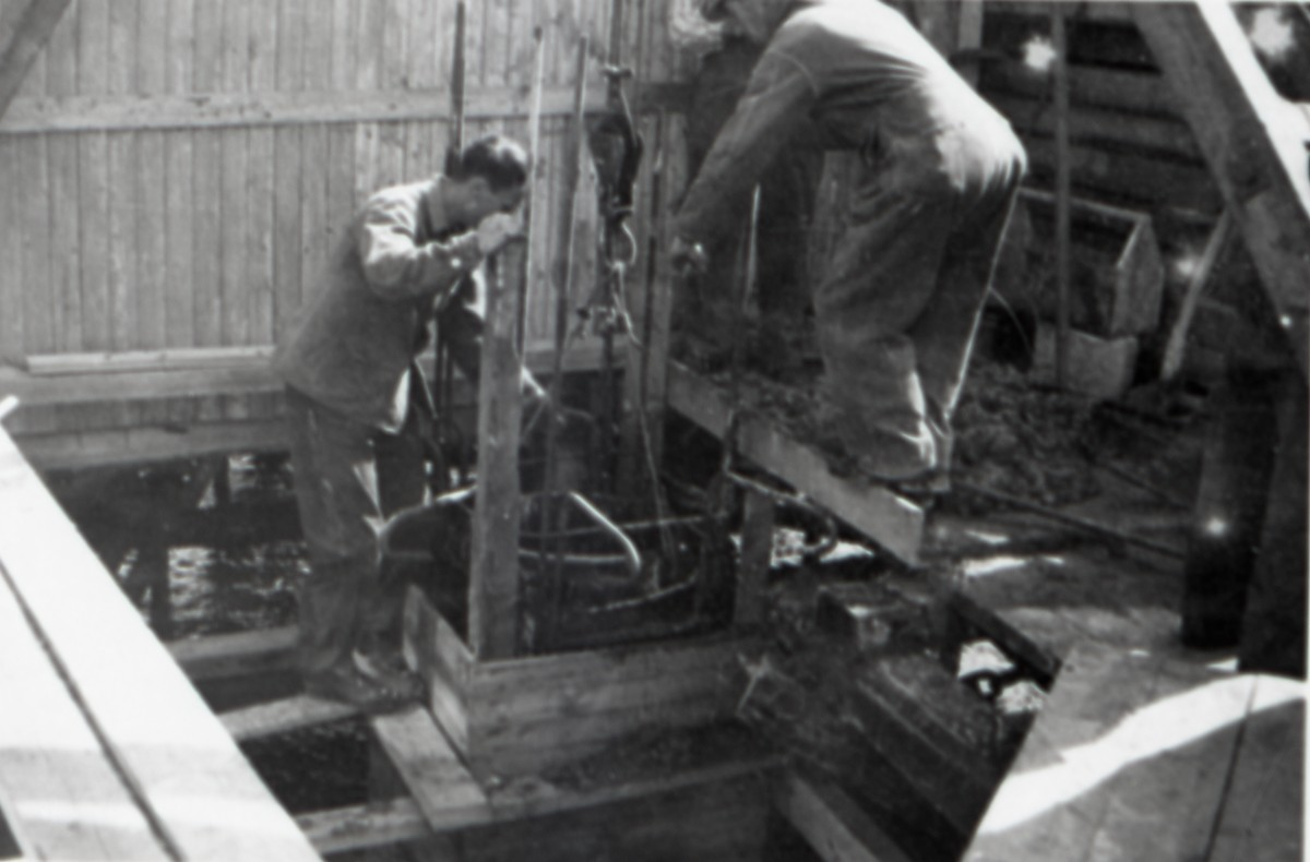 Filetfabrikken på Melbu under bygging. To anleggsarbeidere arbeider med støpingen av den første kaipillaren
