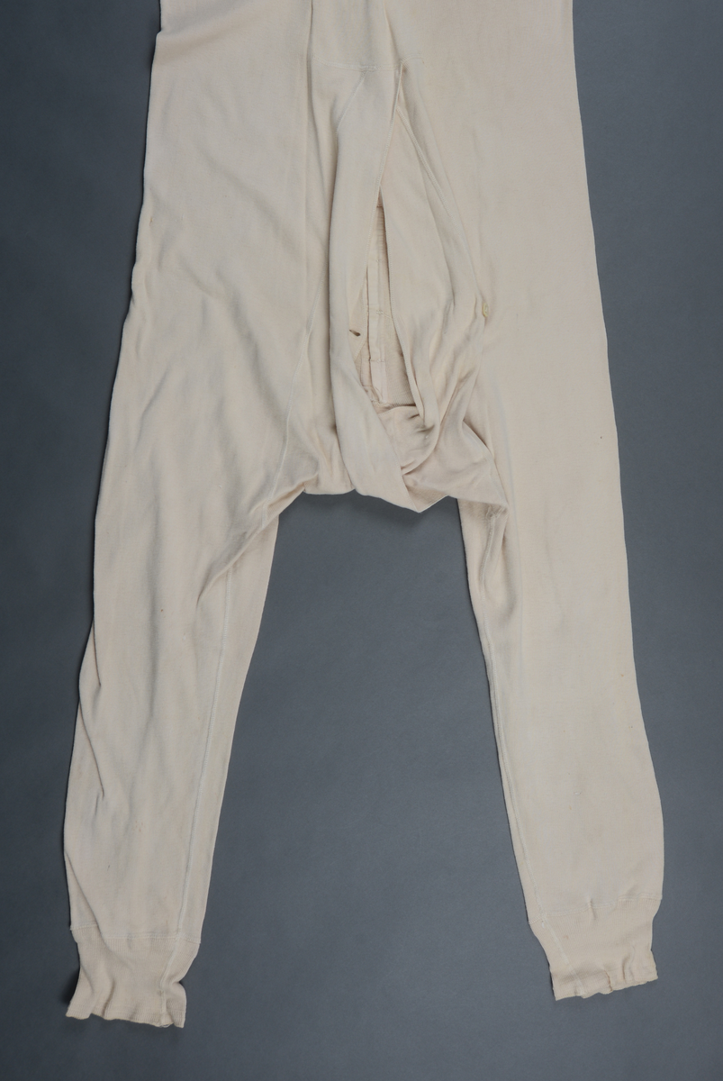 Langunderbukse og underskjorte m. lange ermer i ett: Kombinasjon m. 8 knapper i skjorten foran. Stor åpning i buksebaken med en knapp til lukking.