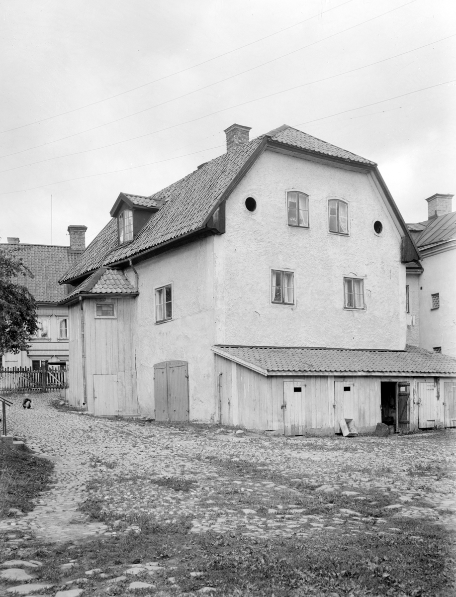Gårdsinteriör från Stenhusgården i Linköping. Miljön är till dags dato i det närmaste oförändrad, vilket gör det medeltida stenhuset till ett av stadens äldst bevarade byggnader. Foto från omkring 1930 som tillskrivs Linköpingsfotografen Lars Fredrik Lovén.