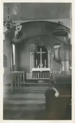 Et bilde av interiøret i en kirke. Bildet er tatt ned kirkeg