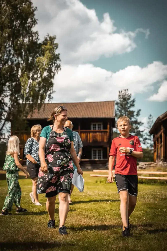 Gjester på museumstunet med Eikjebygningen i bakgrunnen