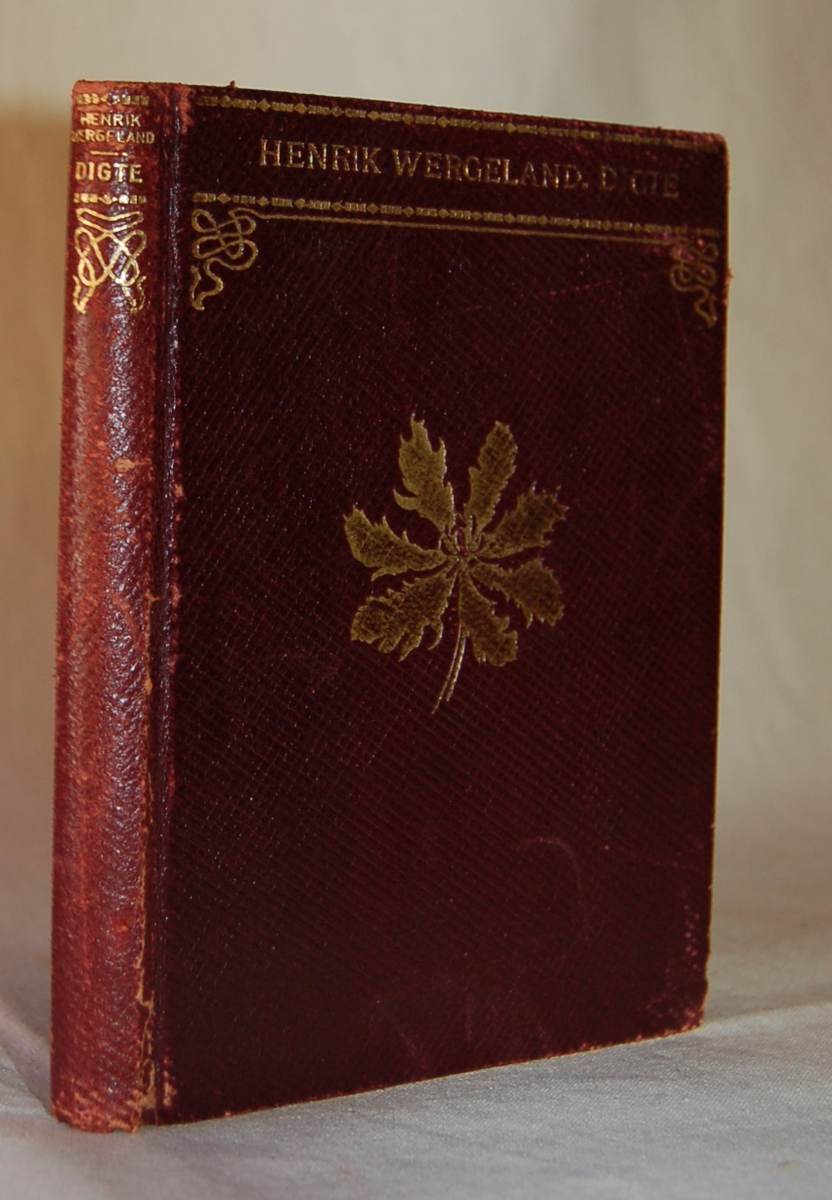 Et blad i gull på bokens forside