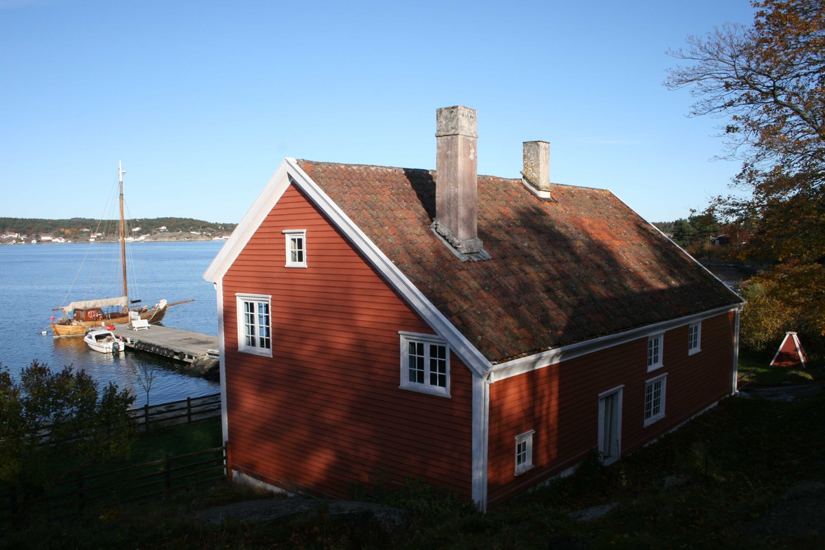 Merdøgaard, gårdstun, sett fra V. Våningshusets gavl mot vest, Revesandsfjorden i bakgr.  