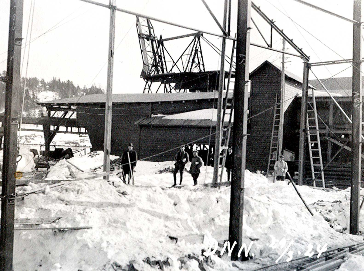 "29/03-1924" Nitriden. Bygging av stekeribygning for steking av elektrodekull. Jernkonstruksjoner. Kran på kai, Tromøysund og Tromøy i bakgrunnen.