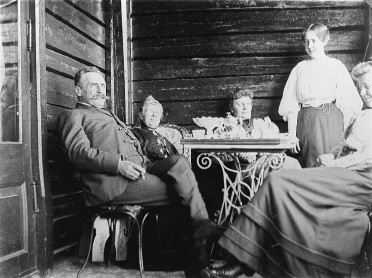 Familien Klouman ved kaffebordet på verandaen på Waldemarhøy