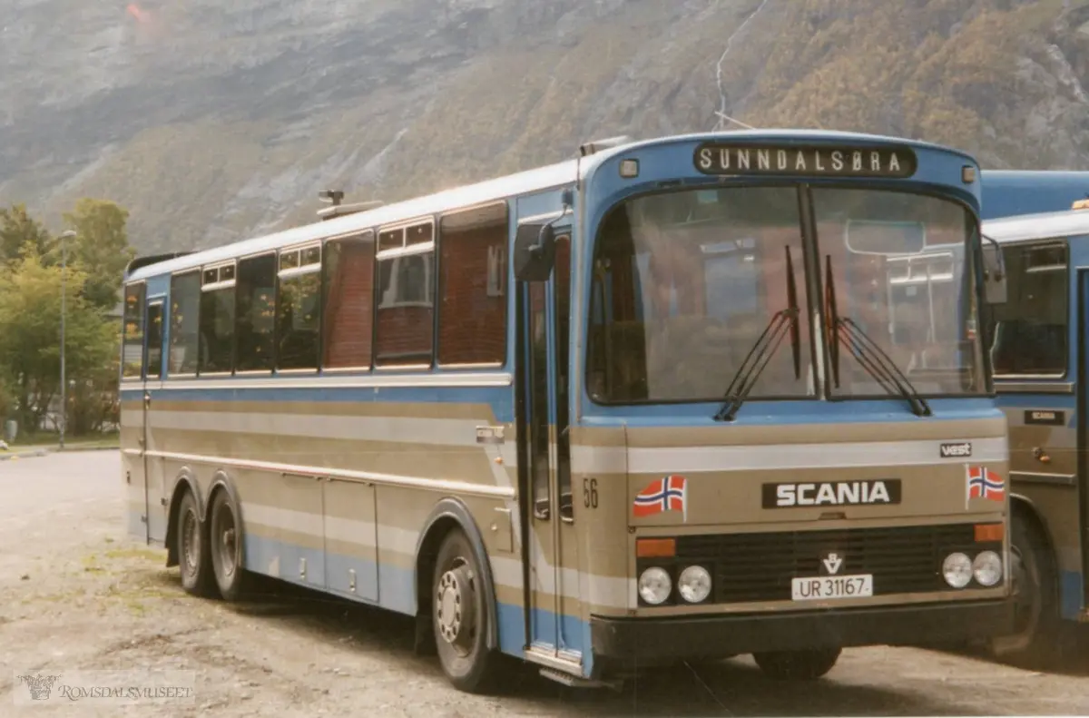 UR31167 er en Scania BR145, 1978-modell, med karosseri fra Vest Karosseri i Stryn. Den ble levert ny til Eira-Eidsvåg Billag som i 1982 ble fusjonert med Kristiansund-Oppdal Auto (KOA) på Sunndalsøra. Den ble da omlakkert i fargene til KOA som på dette bildet. Den ble solgt ut av selskapet i 1994 og har gått en årrekke som campingbuss på Jæren (fremdeles i bruk som camingbuss 2021). Se ellers bilde R.Fot.34340..(fra Oddbjørn Skjørsæter sine samlinger i Romsdalsarkivet)