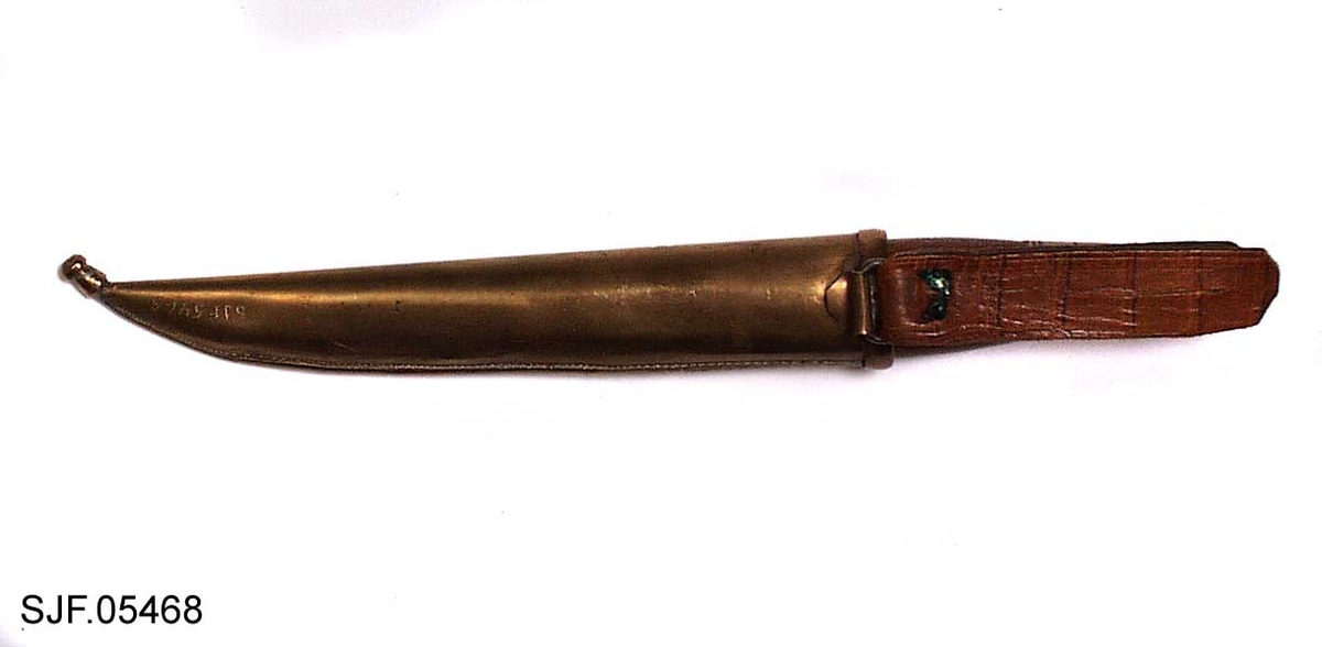 Kniven har brunbeiset skaft, antageligvis av bjørk. Slire og holker er av messing. Slira er foret med papp. Hempa er av imitert krokodilleskinn. Kniven er innkjøpt sammen med andre kniver i ei samling fra Birger Arntzen. 
