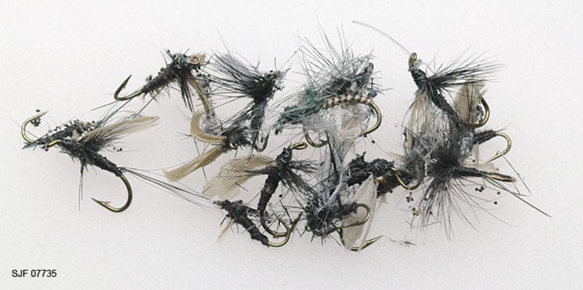 Tilstand: I forbindelse med omfotografering av gjenstander høsten 2002 fant OT Ljøstad at alle fluene i ett av eskens rom var helt ødelagte av møll, mens fluene i et annet rom var delvis ødelagte.  Skadene skyldes lagring i magasin C, som har temperaturforhold som møllen tåler. 

Boksen inneholder ialt 104 fluer. For å nevne noen: Red Tag og Black Gnat. Tørrfluen flyter og kan sees selv i dårlig belysning da den flyter høyt på grunn av de lange armene. Boksen har ialt 10 rom. Giveren har skrevet ei bok med navnet "Isfiske" sammen med Knut Rom. Giverens far var en ivrig sportsfisker og er gitt tittelen "Den fullendte sportsfisker". 