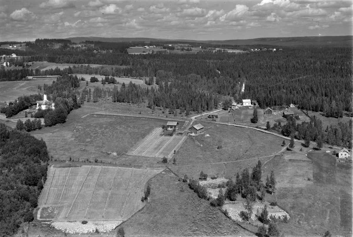 Flyfoto av Åsmarka kapell og området rundt. Midt i bildet: Kirkenær. Helt til høyre Fleskerud