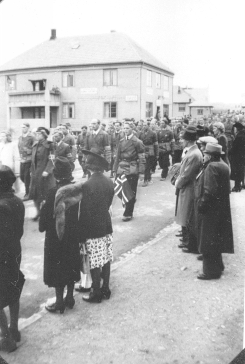 17. maitog 1945, hjemmefronten marsjerer i Furnesvegen, Brumunddal foran Promenadekafeen.